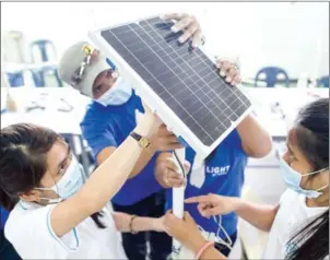  ?? NOEL CELIS/AFP ?? Trainees assemble a solar lantern at a workshop in Manila.