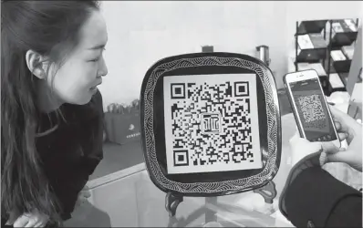  ?? XINHUA ?? A visitor scans the QR code on a ceramic platter for more informatio­n at the Cizhou Kiln Museum of Art in Handan, Hebei province.