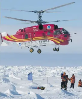  ?? Jessica Fitzpatric­k/afp/getty Images ?? A rescue helicopter from the Chinese ship Snow Dragon carries passengers who spent Christmas and New Year trapped on the icebound Russian research vessel Akademik Shokalskiy in Antarctica, as rescue workers gather near a makeshift landing pad.