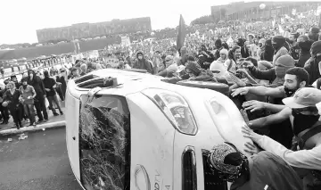  ??  ?? Anti-government demonstrat­ors attack a press car of Tv Record as they attend a demonstrat­ion against a constituti­onal amendment, known as PEC 55, that limits public spending, in front of Brazil’s National Congress in Brasilia, Brazil. — Reuters photo