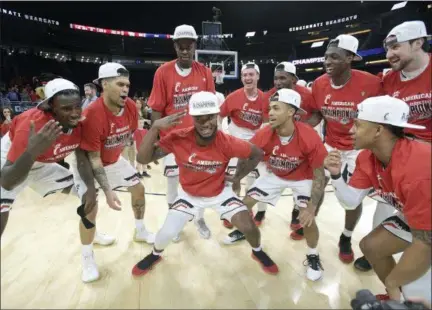  ?? PHELAN M. EBENHACK — ASSOCIATED PRESS ?? Cincinnati guard Trevor Moore, center, celebrates with teammates on the court after they defeated Houston in the American Athletic Conference tournament title game in Orlando, Fla., on Sunday.
