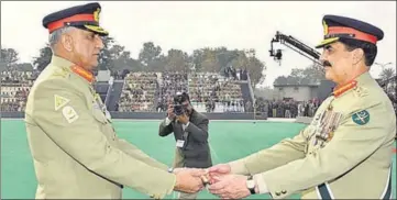  ?? REUTERS ?? Pakistan's outgoing army chief Gen Raheel Sharif (right) hands over a ceremonial baton to his successor Gen Qamar Javed Bajwa at the Change of Command ceremony in Rawalpindi on November 29.