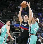  ?? PAUL SANCYA — THE ASSOCIATED PRESS ?? Detroit Pistons forward Bojan Bogdanovic (44) shoots on San Antonio Spurs guard Devonte’ Graham (4) in the first half of Friday’s game in Detroit.