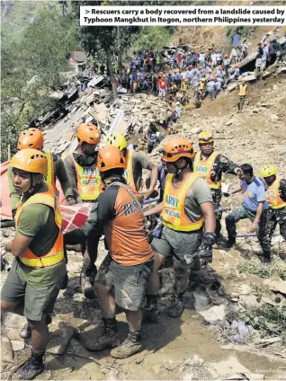  ?? Aaron Favila ?? > Rescuers carry a body recovered from a landslide caused by Typhoon Mangkhut in Itogon, northern Philippine­s yesterday