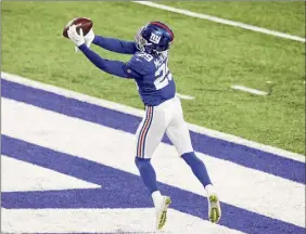  ?? Mike Stobe / Getty Images ?? Xavier Mckinney seals the Giants’ victory as he intercepts a pass from Cowboys QB Andy Dalton during the fourth quarter on Sunday.