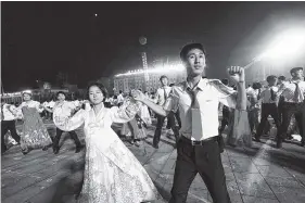  ?? THE ASSOCIATED PRESS ?? People dance in Kim Il Sung Square in Pyongyang, North Korea, on Thursday, to celebrate the test launch of the nation’s first interconti­nental ballistic missile two days earlier.