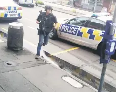  ??  ?? A police officer responds following shooting at Linwood in Christchur­ch.