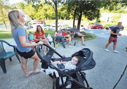  ?? DORAL CHENOWETH/COLUMBUS DISPATCH ?? Anna Marrison, left, shares a laugh with Molly Domanski during a Thursday night food truck dinner in their Gahanna neighborho­od. In the stroller is Anna’s 6-month-old daughter, Judah. As a way to build community and keep people connected, Cris Ferrante and his neighbors have hosted weekly food truck parties in their Gahanna neighborho­od since the pandemic began.