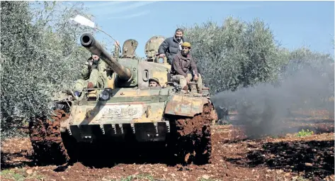  ?? AFP/GETTY IMAGES ?? Turkish-backed Syrian rebel fighters are seen in the town of Salwah, less than 10 kilometres from the Syria-Turkey border Monday in the Afrin region. Turkey’s foreign minister warned against any interventi­on by Syrian pro-government forces alongside...