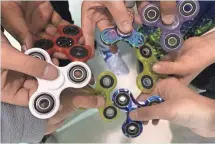  ?? GANNETT FILE ?? Fidget spinners exploded in popularity this spring, but Iowa teachers report interest is waning this fall.