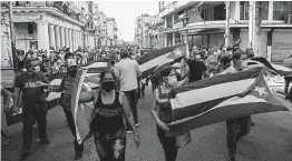  ?? Yamil Lage / AFP / Tribune News Service ?? Thousands of Cubans protest against the communist government, marching through towns chanting “Down with the dictatorsh­ip” and “We want liberty.”