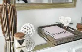  ??  ?? A pink coffee table book paired with brown pottery creates a soothing tabletop vignette.