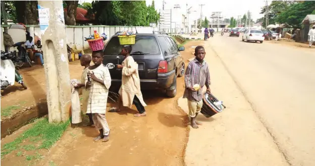  ??  ?? Street life: These Almajirai shine shoes for a few naira