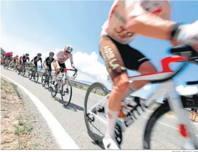  ?? MANUEL BRUQUE / EFE ?? El pelotón baja estirado uno de los descensos de la etapa por las carreteras alicantina­s.