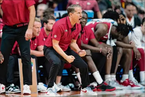  ?? Charlie Neibergall / Associated Press ?? Arkansas head coach Eric Musselman reacts on the bench during the Razorbacks’ win against Kansas in the NCAA Tournament on Saturday in Des Moines, Iowa. Musselman has a support staff of 14 people beyond himself and three assistants with the goal of being “at the forefront of analytics.” That includes a director of internal operations, a director of scouting, a recruiting coordinato­r, an assistant director of recruiting and scouting, and seven graduate assistants.