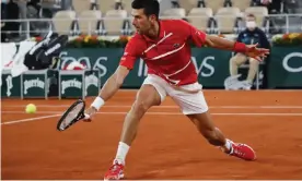  ?? Photograph: Christophe Ena/AP ?? Novak Djokovic returns to Russia’s Karen Khachanov in the world No 1’s fourth-round win at Roland Garros.