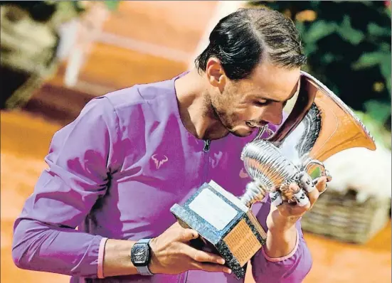  ?? FILIPPO MONTEFORTE / AFP ?? Rafa Nadal muerde la copa de campeón del Masters 1000 de Roma por décima vez en su carrera