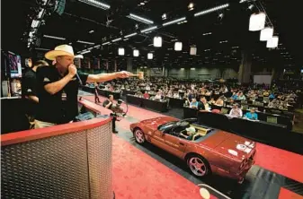  ?? PATRICK CONNOLLY/ORLANDO SENTINEL ?? A vintage Corvette crosses the auction block during the 2021 Mecum Summer Special at Orange County Convention Center.