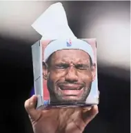  ?? — AFP ?? Wipe away your tears of joy: a fan holds a box of face tissue with the picture of Lebron James during the Lakers’ game against Pacers which they won 112-111.