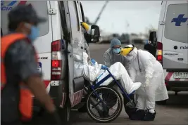  ?? MATILDE CAMPODONIC­O — THE ASSOCIATED PRESS ?? A person from the Australian cruise ship “Greg Mortimer,” who according to the military suffers COVID-19, is taken by military personnel to a local hospital after being removed from the cruise ship in Montevideo, Uruguay, Wednesday.