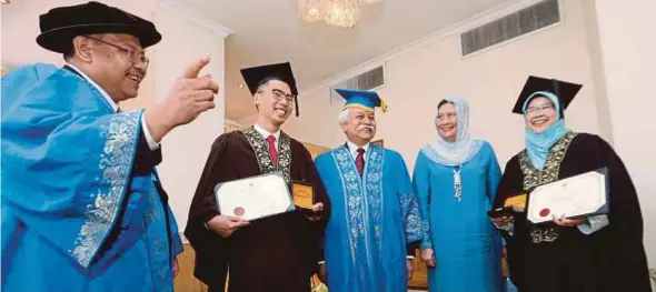  ?? PIX BY EIZAIRI SHAMSUDIN ?? Negri Sembilan Yang di-Pertuan Besar and Universiti Kebangsaan Malaysia chancellor Tuanku Muhriz Tuanku Munawir (centre), Tuanku Ampuan Besar Negri Sembilan Tuanku Aishah Rohani Tengku Besar Mahmud (second from right) and UKM vice-chancellor Tan Sri Dr Noor Azlan Ghazali (left) with Anugerah Pelajaran DiRaja recipients Jason Cheong Kah Lok (second from left) and Sharifah Fatimah Syed Mahusin at the university’s convocatio­n in Bangi yesterday.