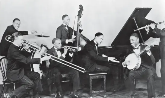  ?? METRONOME/GETTY ?? American jazz pianist and composer “Jelly Roll” Morton plays piano with his band The Red Hot Peppers, circa 1926. The band featured trombonist Kid Ory, drummer William Laws, bassist John Lindsay, banjo player Johnny St. Cyr and clarinetis­t Omer Simeon.