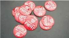 ??  ?? These pins being sold at Nationals Park deliver the one message Democrats and Republican­s can agree on as Washington prepared to host its first World Series game in 86 years on Friday night.