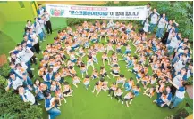  ?? Courtesy of POSCO ?? Kindergart­eners pose with their teachers at a POSCO day care center in Pohang, North Gyeongsang Province, July 25.