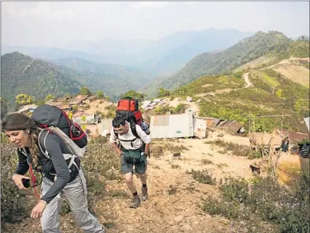  ?? Photograph­s by John Henderson ?? HIKERS tackle the steep, relentless hills of northern Laos as they near Chakhampa village, about 10 miles from the Chinese border.