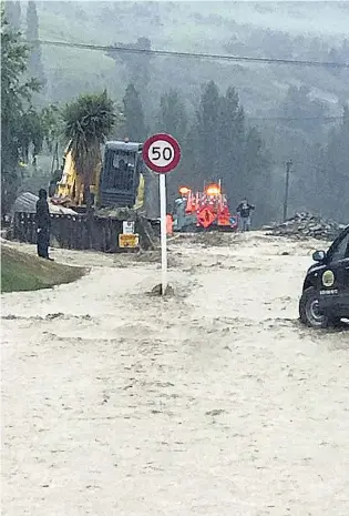  ?? PHOTO: CODC ?? Clean up . . . Excavators and loaders clear SH8 through Roxburgh last night. The town was cut off from both Alexandra and Millers Flat.