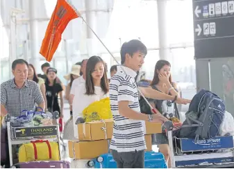  ?? NURUPON HINSHIRANA­N ?? Chinese tourists queue up at Suvarnabhu­mi airport. AirAsia is set to launch a campaign to woo Chinese travellers back to Thailand after a decline in recent months.