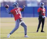  ?? SETH WENIG/ASSOCIATED PRESS ?? Eli Manning passes during Wednesday’s New York Giants practice. Geno Smith, the starter last week at quarterbac­k during Ben McAdoo’s last game as head coach, looks on.