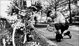  ?? ANDRES KUDACKI/AP ?? Eric Fleming, 41, offers condolence­s Thursday in front of a bike memorial where mourners have left flowers and candles to honor the victims of Tuesday’s attack in New York City.