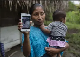  ?? OLIVER DE ROS — THE ASSOCIATED PRESS ?? Claudia Maquin, 27, shows a photo of her daughter, Jakelin Amei Rosmery Caal Maquin, in Raxruha, Guatemala, on Saturday. The 7-year-old girl died last week in a Texas hospital.