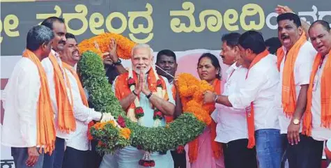  ?? PTI ?? Prime Minister Narendra Modi is garlanded by BJP workers at an election campaign rally in Udupi yesterday.