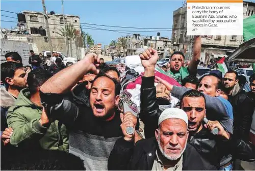  ?? AFP ?? ■ Palestinia­n mourners carry the body of Ebrahim Abu Sha’er, who was killed by occupation forces in Gaza.