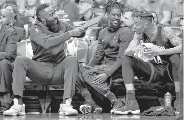  ?? Matt York / Associated Press ?? Guard James Harden, left, recovering from a left hamstring injury, playfully fans his teammates on the bench during the first half of the Rockets’ 112-95 victory over the Suns on Friday night in Phoenix.