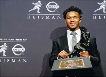  ?? AP PHOTO/CRAIG RUTTLE ?? Oklahoma quarterbac­k Kyler Murray, who won the Heisman Trophy, poses with the award Saturday in New York.