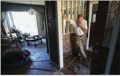  ?? Arkansas Democrat-Gazette/STATON BREIDENTHA­L ?? Floyd Haley talks Monday with an electricia­n about repairs from flood damage to his house on Willow Beach Road in North Little Rock.