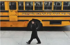  ?? (Shannon Stapleton/Reuters) ?? A BOY walks by a yeshiva school bus in Brooklyn. Antisemiti­c incidents in the city have increased significan­tly this year, according to data from the New York Police Department.