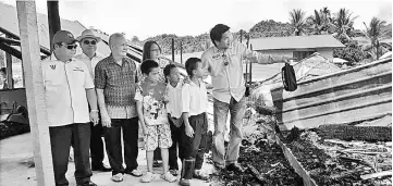  ??  ?? One of the affected students of Sekolah Kebangsaan Long Palai showing Dennis (right) where he slept when the fire raged the longhouse.