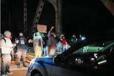  ?? Desiree Rios/New York Times ?? People march along the Arkansas-Memphis bridge on Friday in Memphis, Tenn., to protest the deadly police beating of Tyre Nichols.