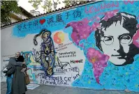  ?? AP ?? A couple hugs by the newly renovated and repainted ‘‘Lennon Wall’’ in Prague, Czech Republic. Scientists have suggested the Beatles’ Ob-La-Di, ObLa-Da is close to being a perfect pop song.