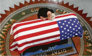  ?? Ross D. Franklin / Associated Press ?? Cindy McCain lays her head on the casket of her late husband, Sen. John McCain, during a memorial service in Phoenix at the Arizona Capitol on Wednesday. A memorial service will be held on Thursday.