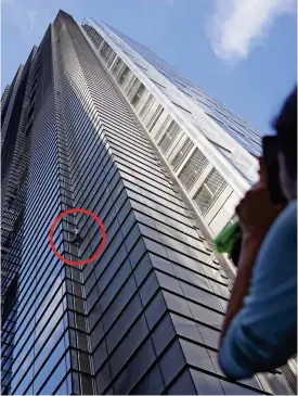  ??  ?? Clinging on: Alain Robert is filmed as he scales the Heron Tower yesterday. Above: The view workers inside had