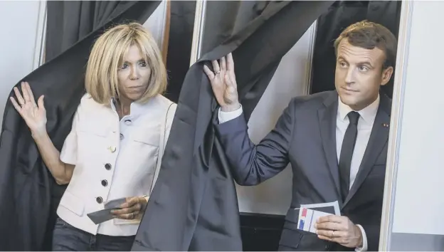  ?? PICTURE: CHRISTOPHE PETIT TESSON/AFP/GETTY IMAGES ?? 0 French President Emmanuel Macron and his wife Brigitte Macron leave the polling booths after voting in Le Touquet