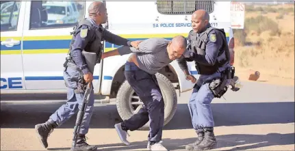  ??  ?? PROTEST: Hundreds of community members blocked the road between Barkly West and Delportsho­op with burning tyres and rocks. Police detained a man who was part of the protest in the area (above).
Picture: