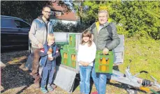  ?? FOTO: GISELA SGIER ?? Der Leutkirche­r Peter Stotz (rechts) und Enkeltocht­er Julia (Zweite von rechts) decken sich mit frisch gepresstem Apfelsaft ein. „Kernig“- Mitorganis­ator Michael Gretz (links) mit Sohn Elias freuen sich über die Abnehmer.