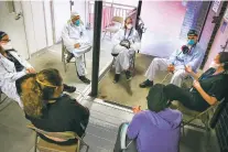  ?? ROBERT BUMSTED/ASSOCIATED PRESS ?? Hospital workers sit for a group counseling session May 29 at Elmhurst Hospital in New York to talk about their experience­s dealing with the COVID-19 pandemic. At hospitals around the country, nurses, doctors and other health care workers are reckoning with the psychologi­cal toll of the virus fight, coupled with fears that the disease could flare anew later this year.