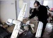  ?? KHALID MOHAMMED/AP ?? An Iraqi officer inspects drones seized from an Islamic State warehouse where militants modified them for war.